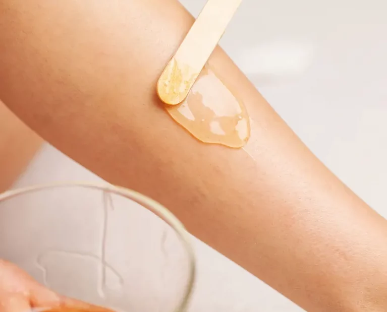 Waxing in mannheim Kosmetikstudio für Hautpflege, eine frau trägt wachs auf ihr bein auf, um haare zu entfernen